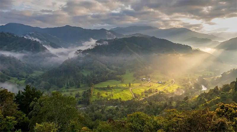 Paisaje natural de un valle montañoso que representa un Área de Vida oficial inscrita en el REAA (Registro Único de Ecosistemas y Áreas Ambientales). Este ecosistema estratégico es gestionado por Vivero Harmony para que las empresas medianas y grandes de Bogotá puedan ejecutar su plan de siembra de árboles nativos y cumplir con la Ley 2173 sin necesidad de comprar terrenos propios